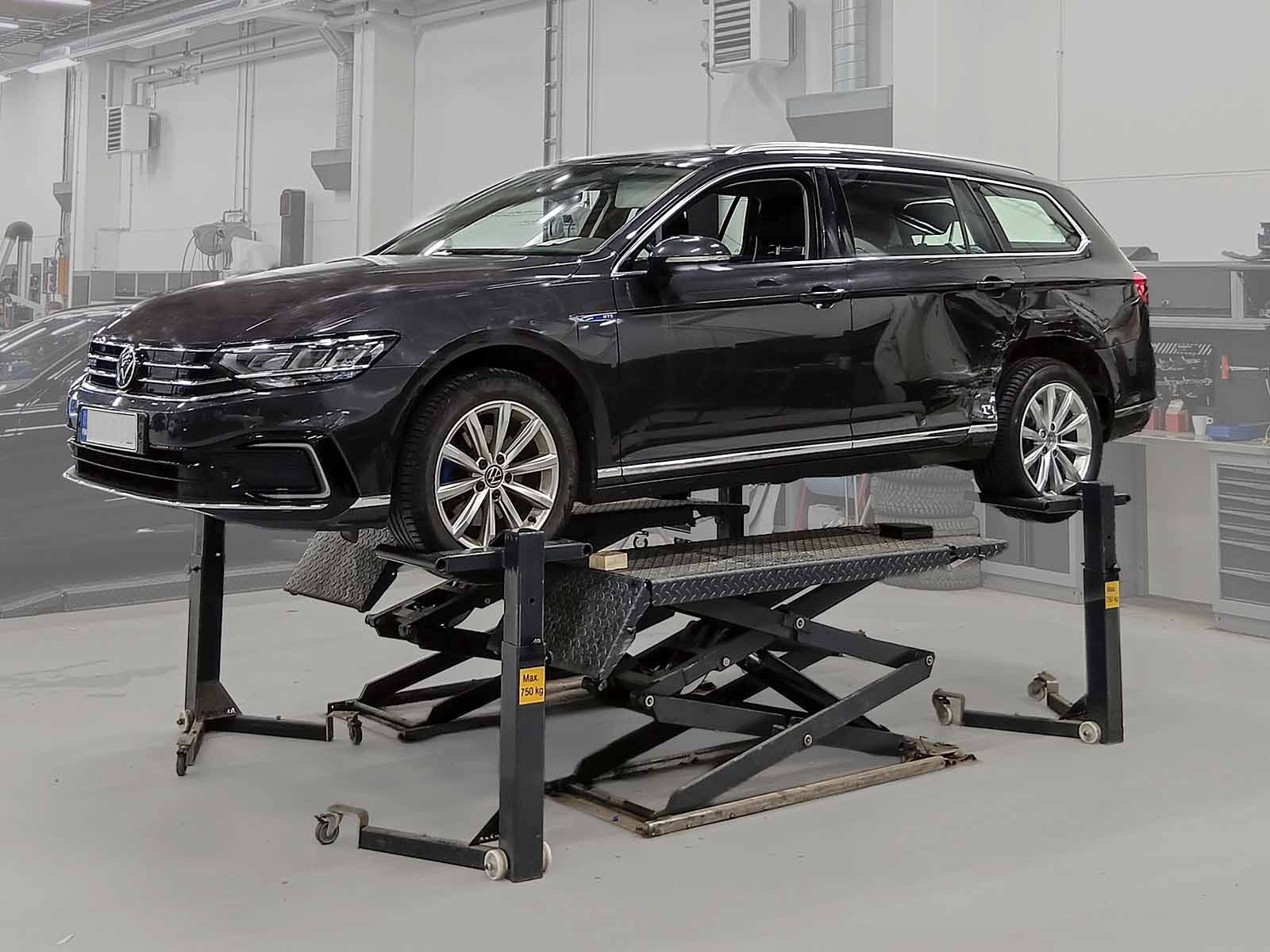 autorobot-car-wheel-stands-2 Car supported on Autorobot wheel stands above a scissor lift in a repair workshop.